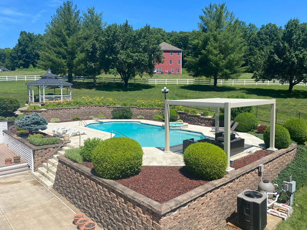 Modern shade pergola next to a backyard swimming pool